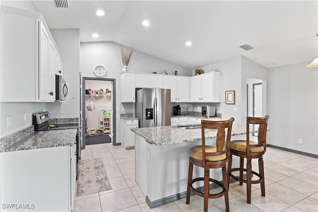 kitchen with white cabinetry, stainless steel appliances, light tile patterned flooring, lofted ceiling, and light stone countertops