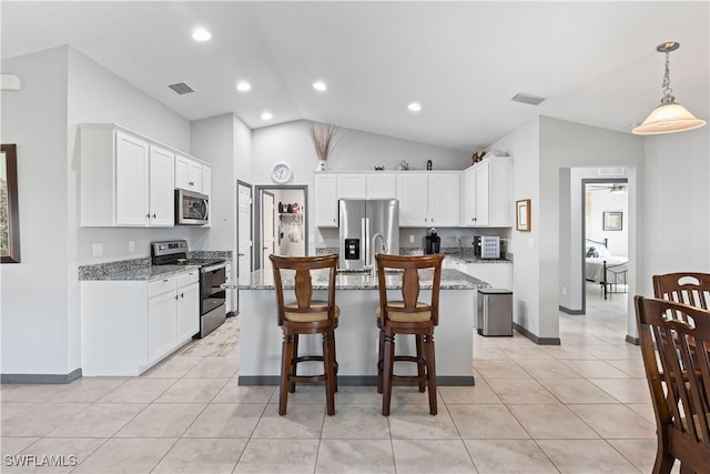 kitchen with light stone countertops, pendant lighting, stainless steel appliances, and a center island with sink