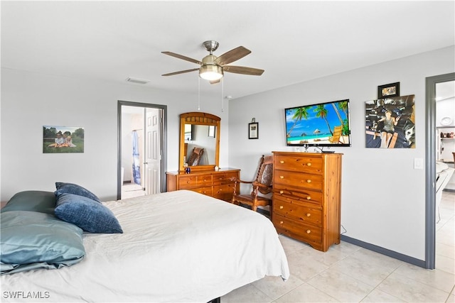 bedroom featuring ceiling fan, light tile patterned floors, and ensuite bath