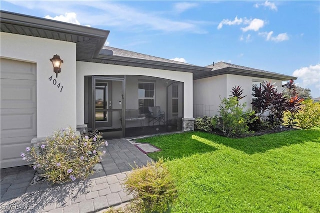 doorway to property featuring a garage and a lawn