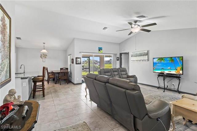 living room with ceiling fan, light tile patterned floors, sink, and lofted ceiling