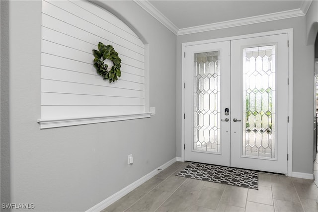 foyer entrance with ornamental molding, french doors, and baseboards