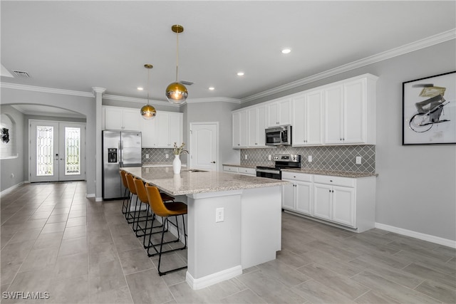 kitchen featuring a center island with sink, french doors, stainless steel appliances, and white cabinets