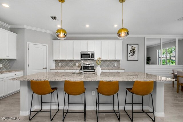 19644 The Place Blvd, Estero, FL 33928 - kitchen featuring stainless steel appliances, a sink, crown molding, backsplash, and white cabinetry
