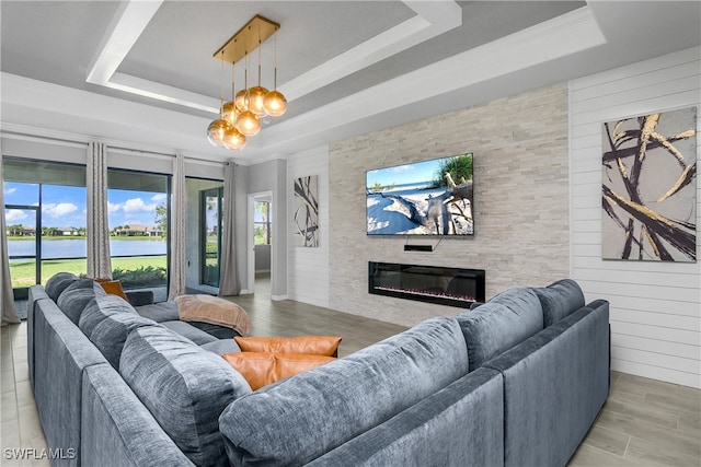 living area featuring a large fireplace, a raised ceiling, light wood-style flooring, and wooden walls