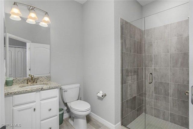 full bathroom featuring toilet, a shower stall, vanity, tile patterned flooring, and baseboards