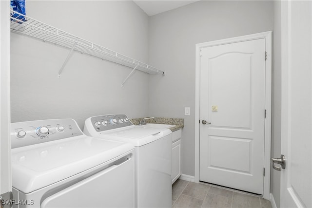 laundry area featuring a sink, cabinet space, baseboards, and washer and dryer