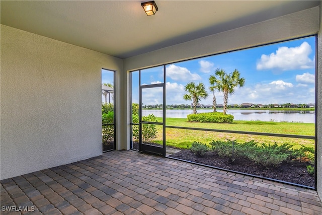 unfurnished sunroom with a water view