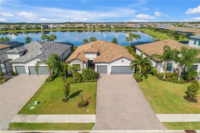 19644 The Place Blvd, Estero, FL 33928 - view of front facade featuring an attached garage, decorative driveway, a residential view, and a water view