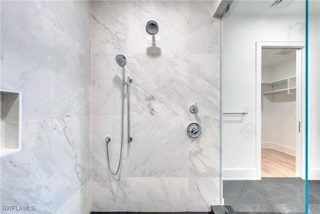 bathroom featuring hardwood / wood-style floors and tiled shower