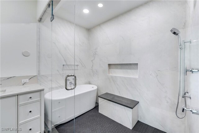 bathroom with plus walk in shower, vanity, and tile walls