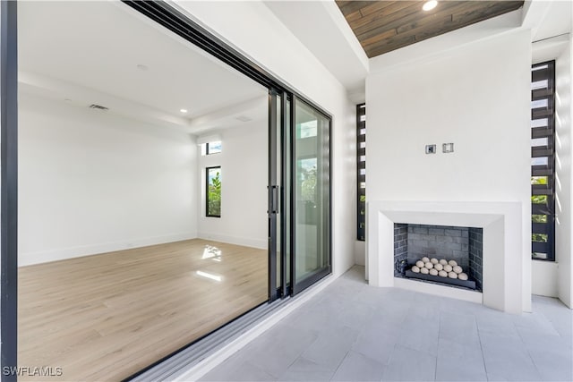 unfurnished living room with wooden ceiling and light wood-type flooring