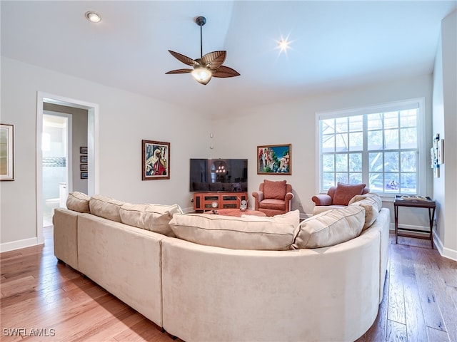 living room featuring light hardwood / wood-style flooring and ceiling fan