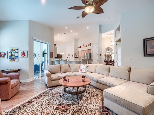 living room featuring wood-type flooring and ceiling fan with notable chandelier