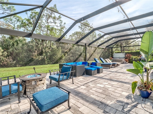 view of patio featuring a lanai and an outdoor living space with a fire pit