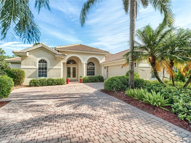 mediterranean / spanish house with french doors and a garage