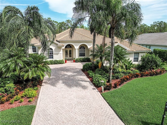 mediterranean / spanish house featuring a front yard