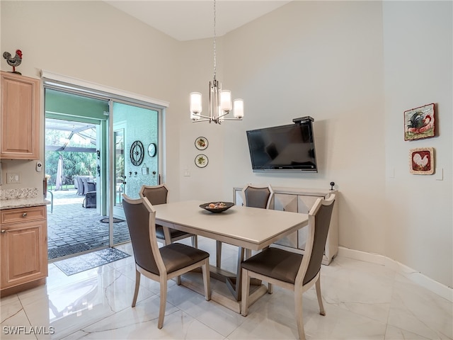 dining space with a notable chandelier and a towering ceiling