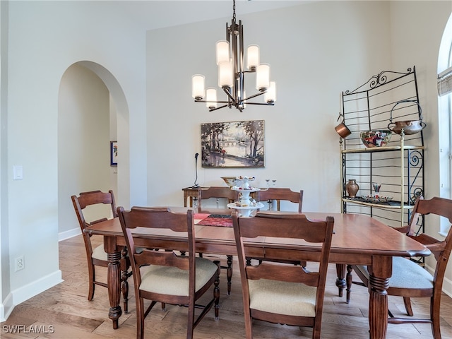 dining room with light hardwood / wood-style floors and a notable chandelier