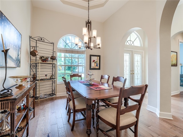 dining space featuring hardwood / wood-style flooring, an inviting chandelier, and plenty of natural light