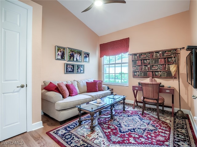 living room featuring hardwood / wood-style flooring, ceiling fan, and vaulted ceiling