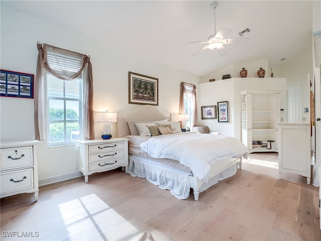 bedroom with ceiling fan, lofted ceiling, and light wood-type flooring