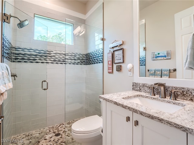 bathroom with vanity, toilet, and a shower with door