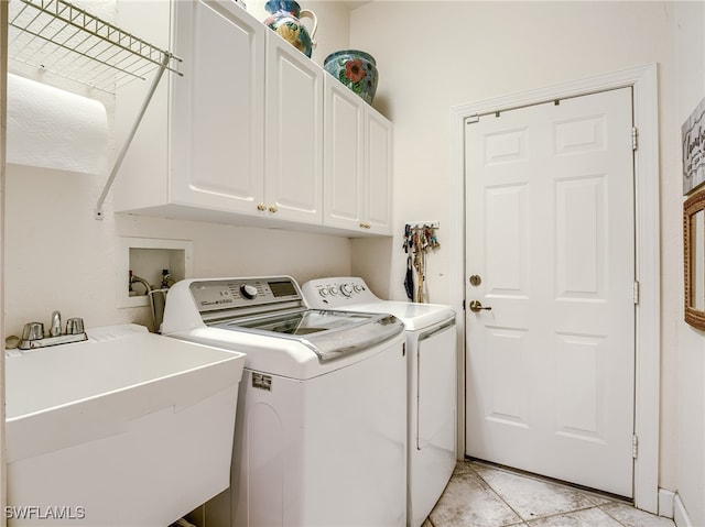 washroom featuring sink, washer and clothes dryer, light tile patterned floors, and cabinets