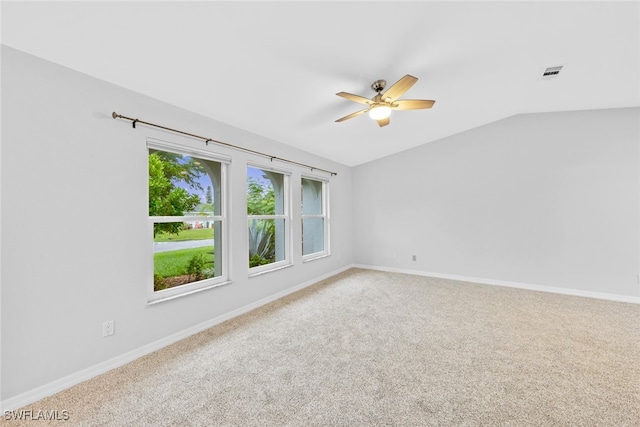 carpeted empty room featuring vaulted ceiling and ceiling fan