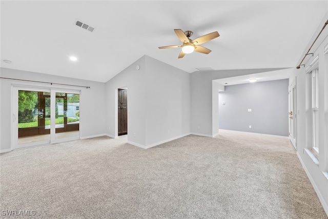 spare room featuring ceiling fan, light colored carpet, and vaulted ceiling