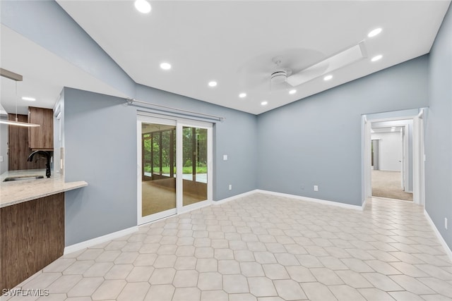 unfurnished living room with lofted ceiling, sink, and ceiling fan