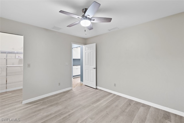 spare room with ceiling fan and light wood-type flooring