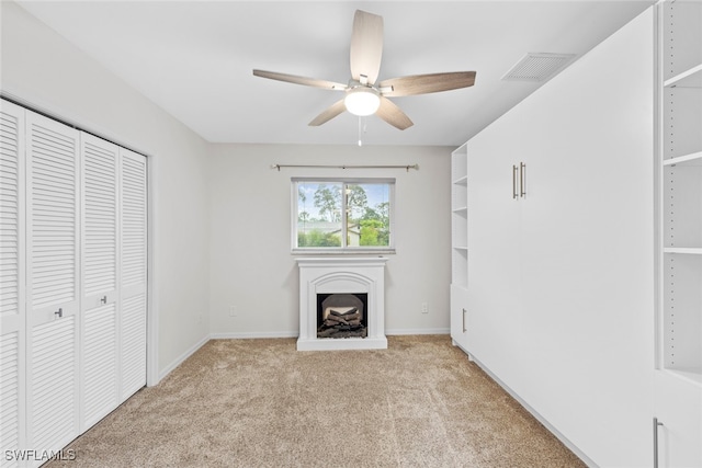 unfurnished living room with light colored carpet and ceiling fan