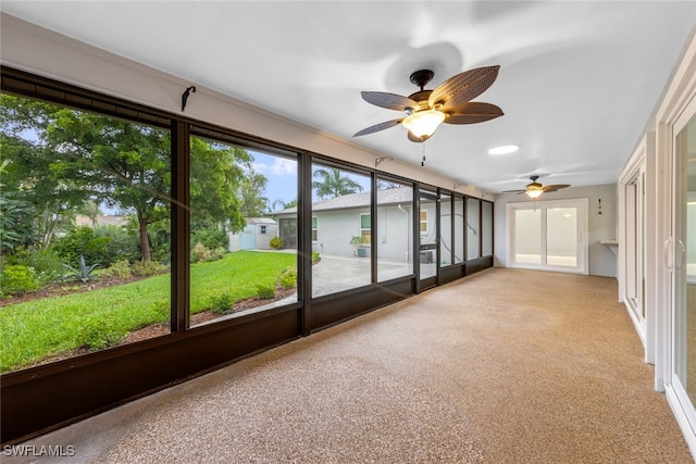 unfurnished sunroom with ceiling fan