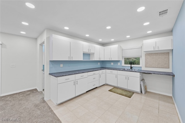 kitchen featuring white cabinetry, light tile patterned floors, and sink