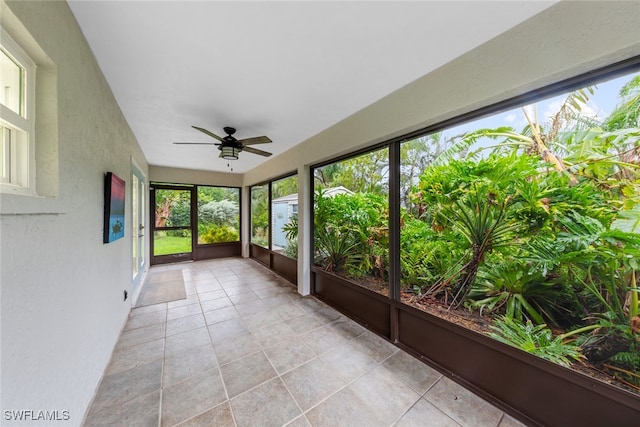 unfurnished sunroom featuring ceiling fan