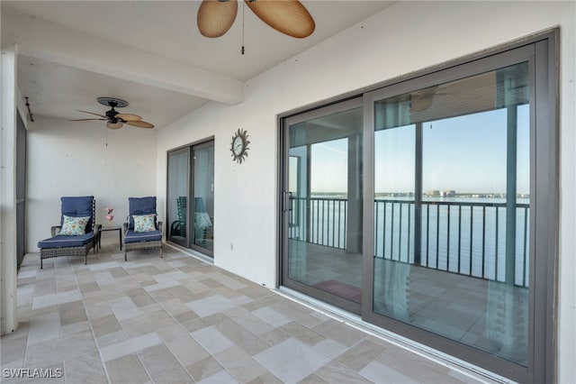 view of patio featuring a water view and ceiling fan