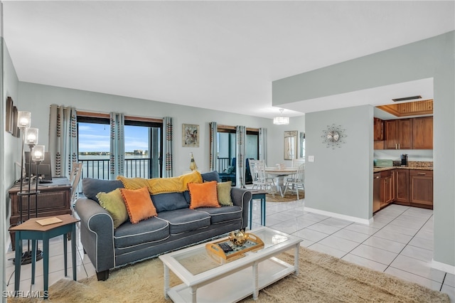 living room featuring light tile patterned floors and a water view