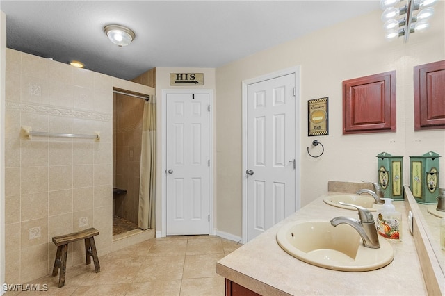 bathroom with vanity, tile patterned flooring, and a tile shower