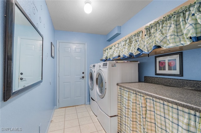 clothes washing area with a textured ceiling, light tile patterned flooring, and independent washer and dryer