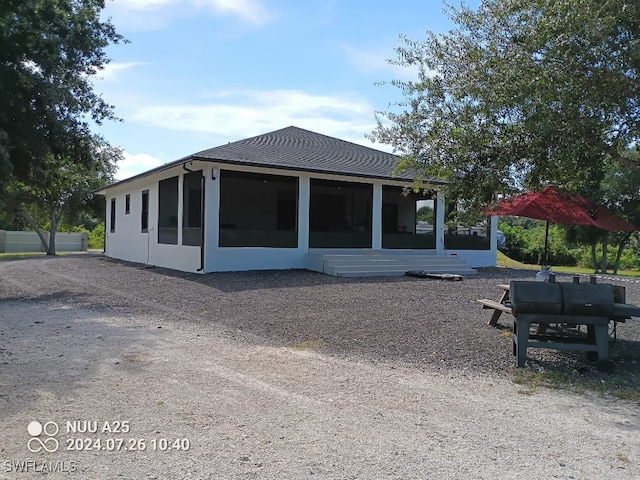 rear view of house featuring a sunroom