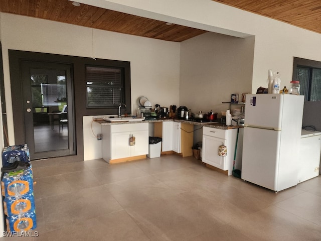 kitchen featuring sink, white cabinets, white fridge, and wood ceiling