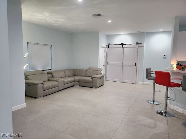 living room featuring light tile patterned flooring and a barn door