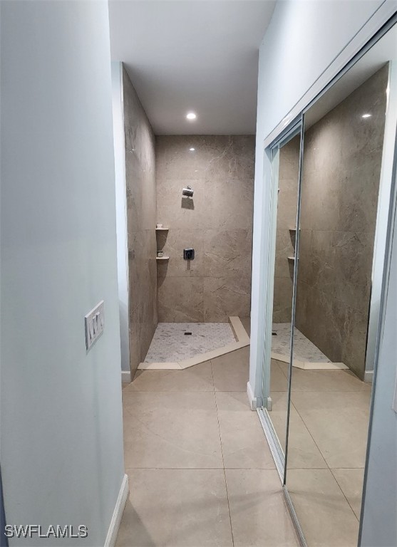 bathroom with tile patterned floors and tiled shower