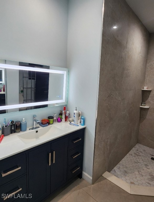 bathroom featuring vanity, a tile shower, and tile patterned floors