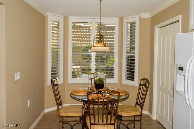 tiled dining space featuring ornamental molding and a healthy amount of sunlight