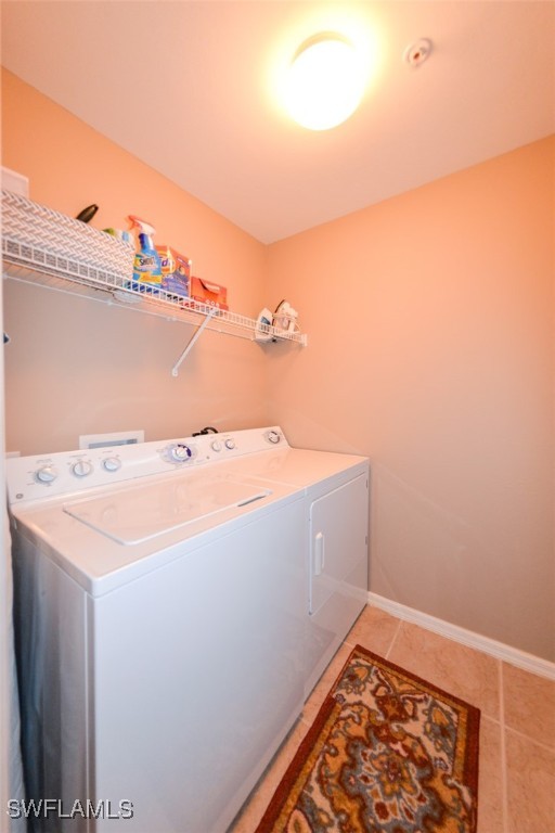 washroom with independent washer and dryer and tile patterned flooring