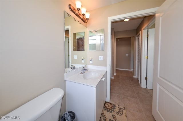 bathroom with tile patterned flooring, vanity, and toilet