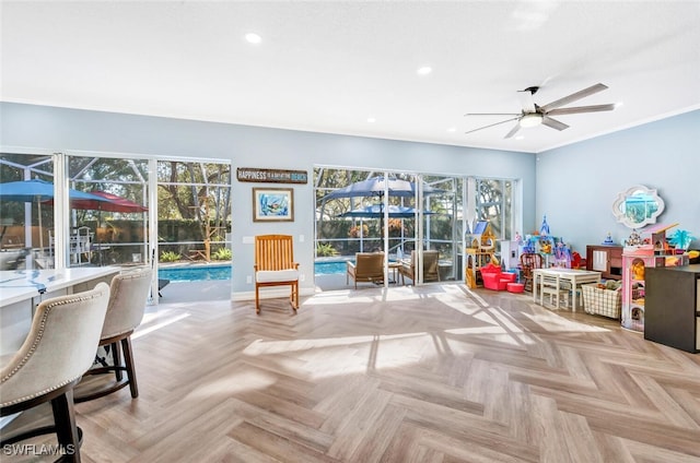 game room with light parquet flooring, plenty of natural light, ceiling fan, and a swimming pool