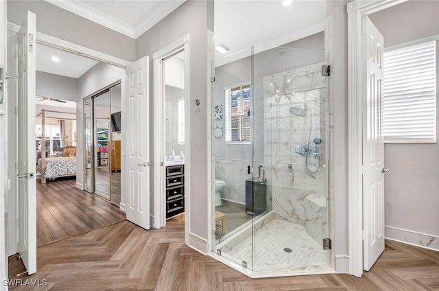 bathroom featuring parquet floors, vanity, crown molding, toilet, and a shower with shower door